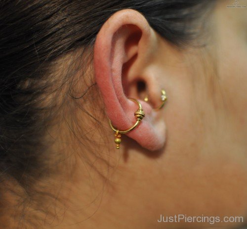 Golden Orbital And Tragus Piercing