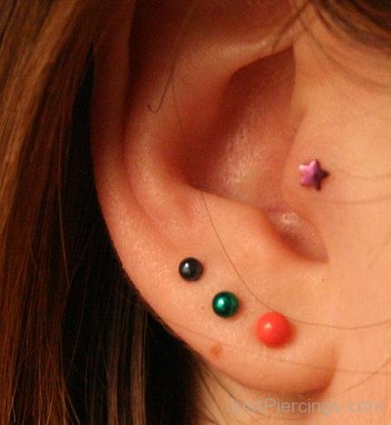 Star Tragus And Orange Lobe Piercing