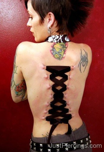 Corset Piercing With Spider Tattoo